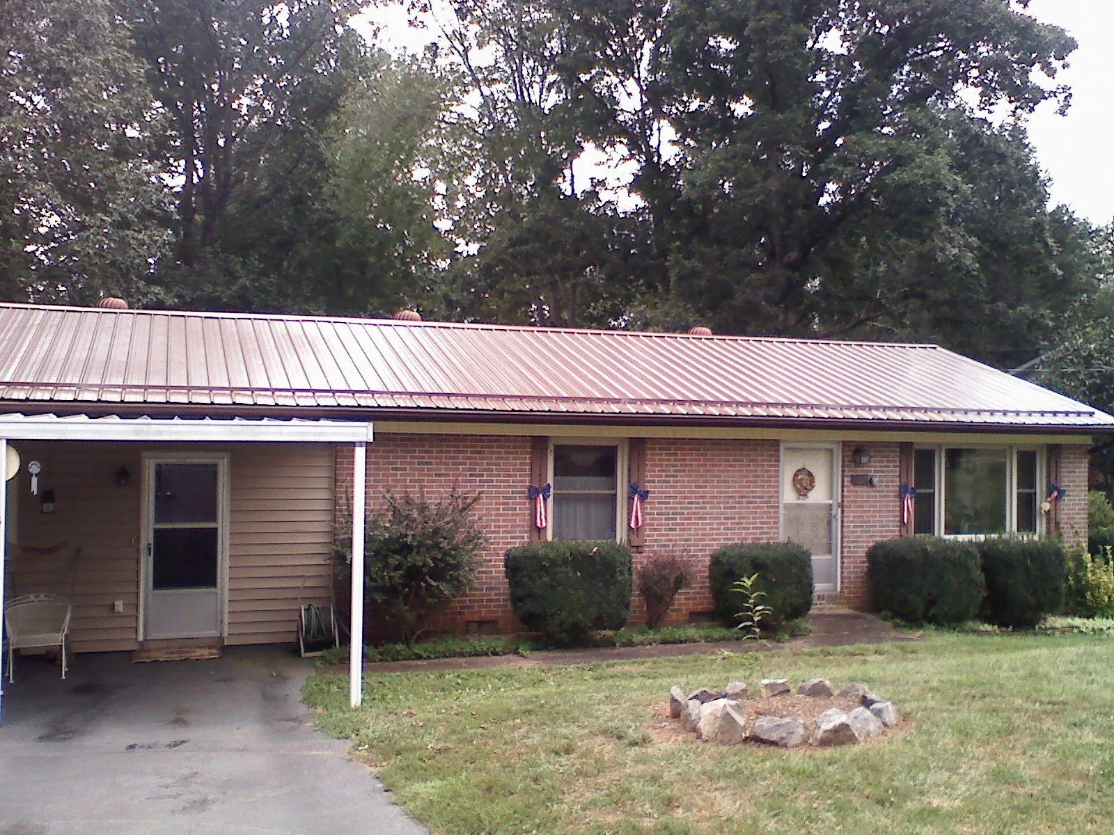 Bronze metal roof and carport on a brick ranch home — Roof Repair work by our crew in Fork Union